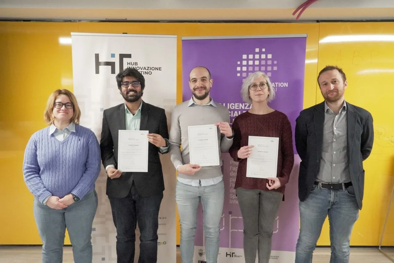 The winning team holding certificates at the Public AI Challenge award, in front of Fondazione HIT banners.