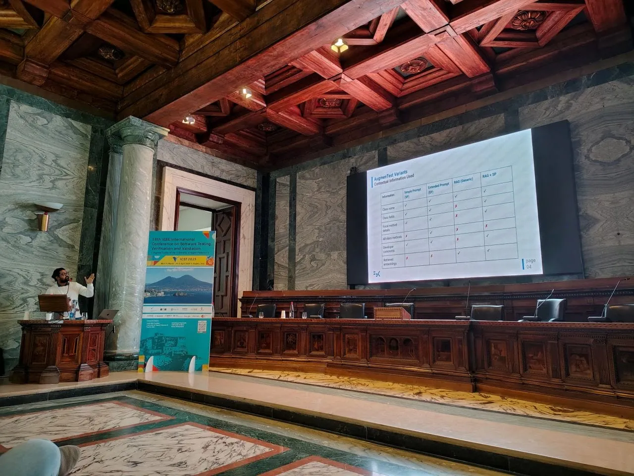 A results table from the AugmenTest evaluation projected in the conference hall at ICST 2025, the speaker at a lectern.